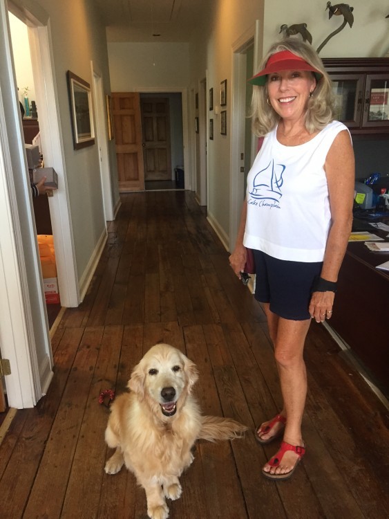 Woman standing in town offices with her golden retriever sitting next to her
